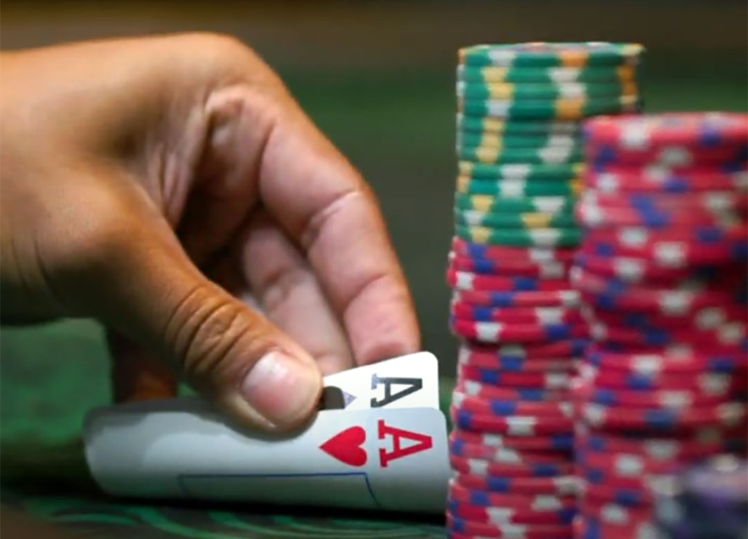 Player showing 2 aces next to poker chips